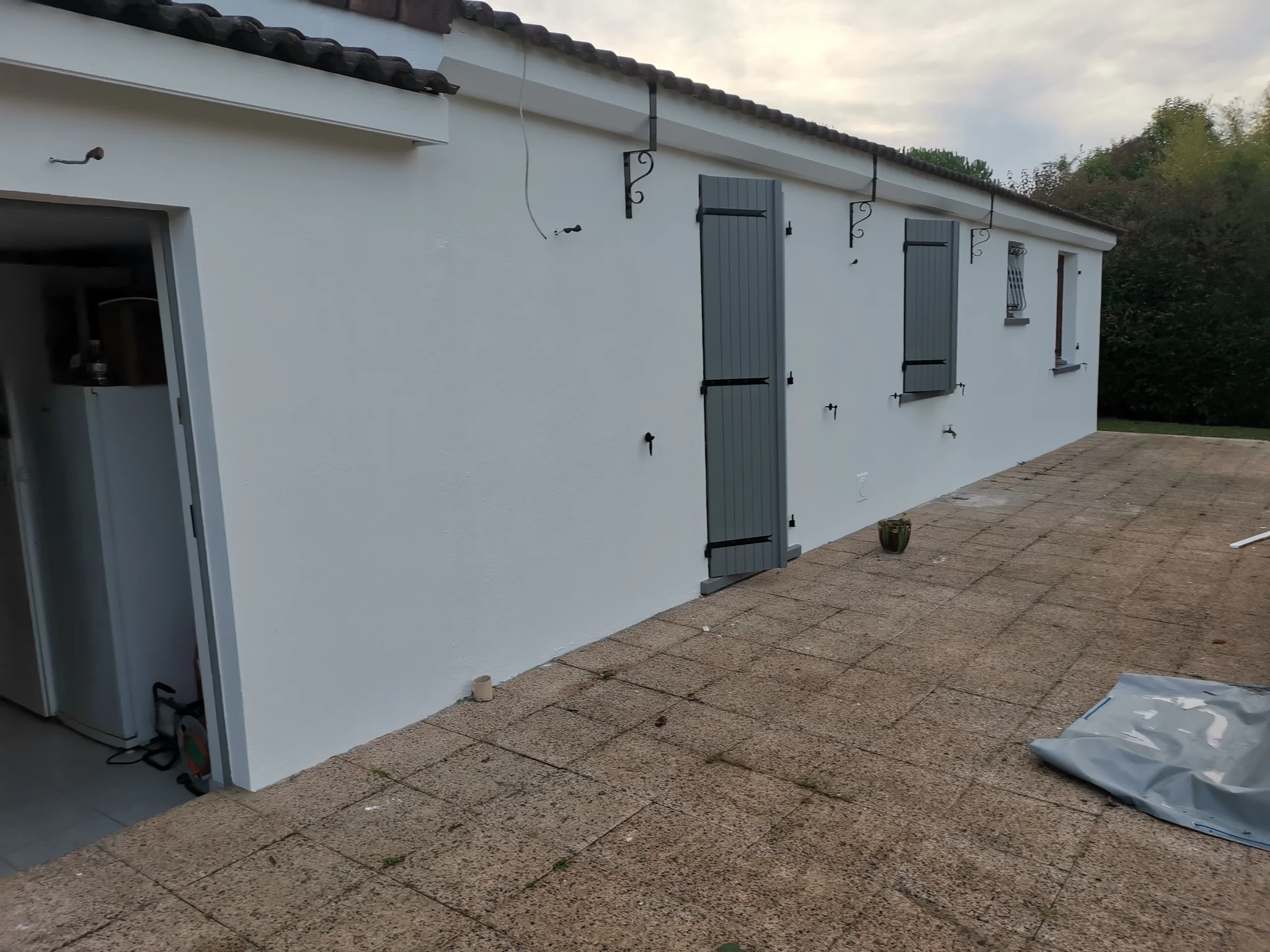 Façade de plain-pied repeinte en blanc avec volets gris