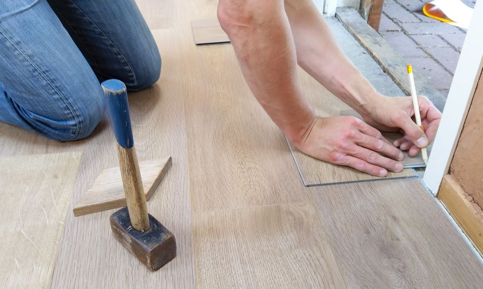 Artisan traçant une lame vinyle à clipser avant découpe