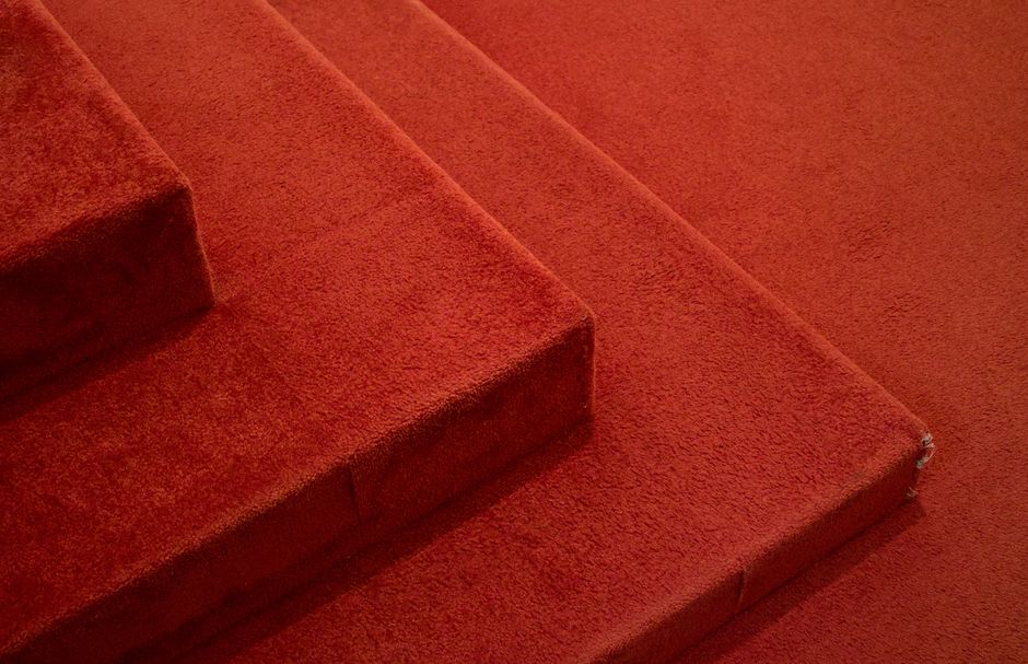Gros plan sur des marches recouvertes de moquette rouge