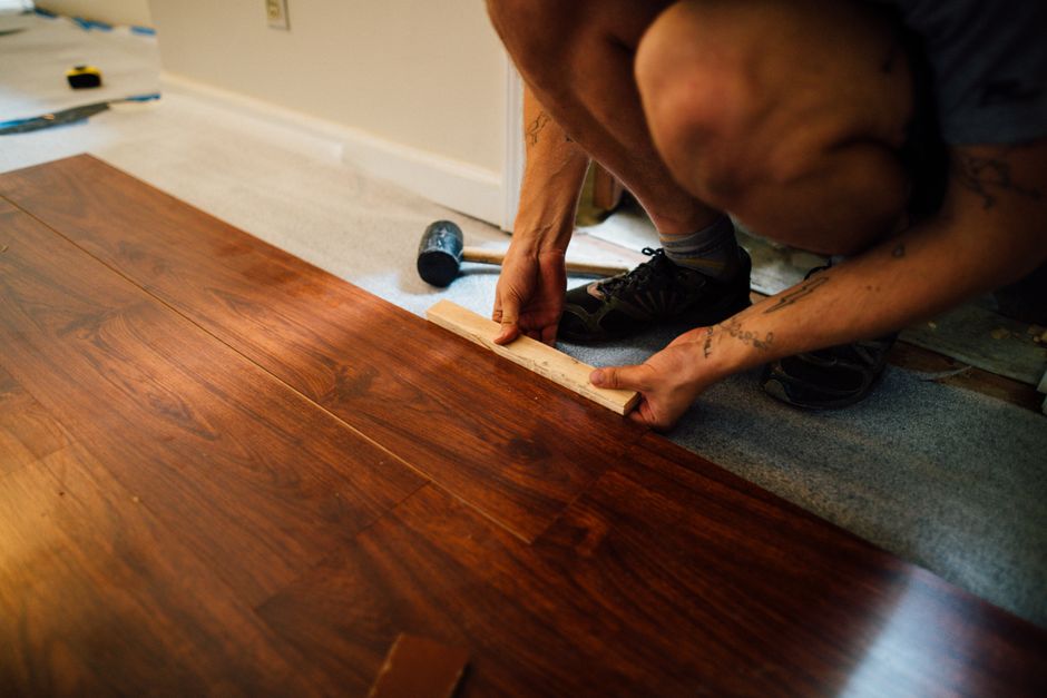 Artisan posant des lames de parquet stratifié au maillet