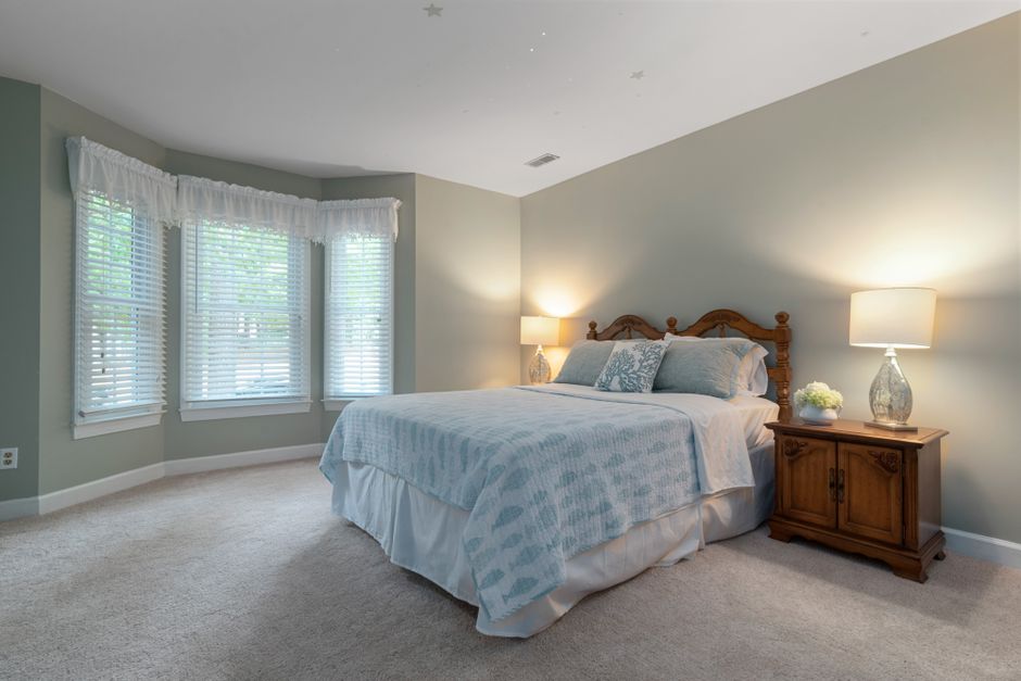 Chambre lumineuse au sol recouvert d'une moquette beige